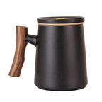 Matte black porcelain mug with wooden handle, lid, and built-in infuser, 12 fl.oz. capacity, modern design.