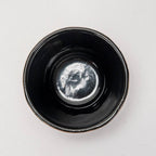 Top-down view of glossy deep purple cast iron drinkware with smooth glaze and subtle honeycomb texture inside bowl.