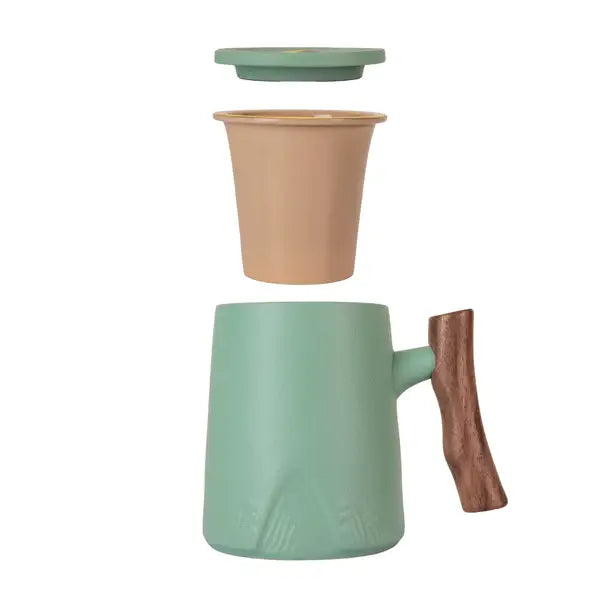 Porcelain green mug with wood-textured handle, beige infuser, and matching lid shown separated on white background