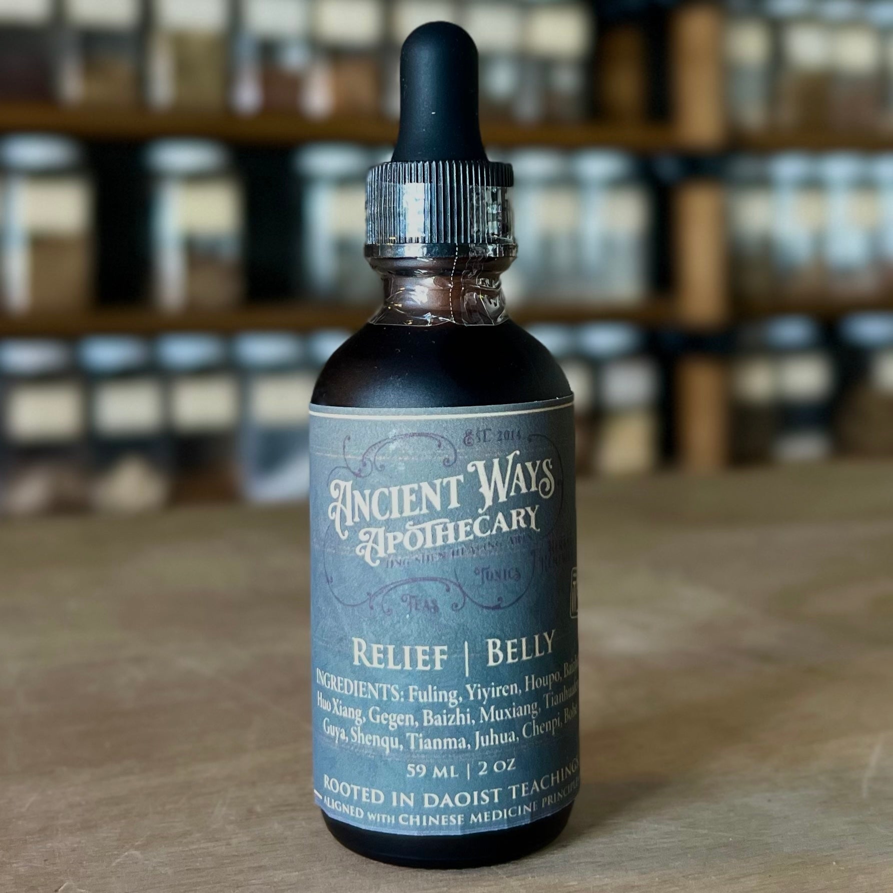 Dark glass tincture bottle with dropper, labeled Relief Belly digestive support blend from Ancient Ways Apothecary.