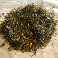Close-up of Apricot Breeze loose green tea blend with apple pieces and dried apricot bits on parchment paper.