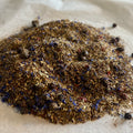 Loose Blue Green Dragon rooibos tea blend with green rooibos, blueberries, and natural caffeine-free ingredients on paper.