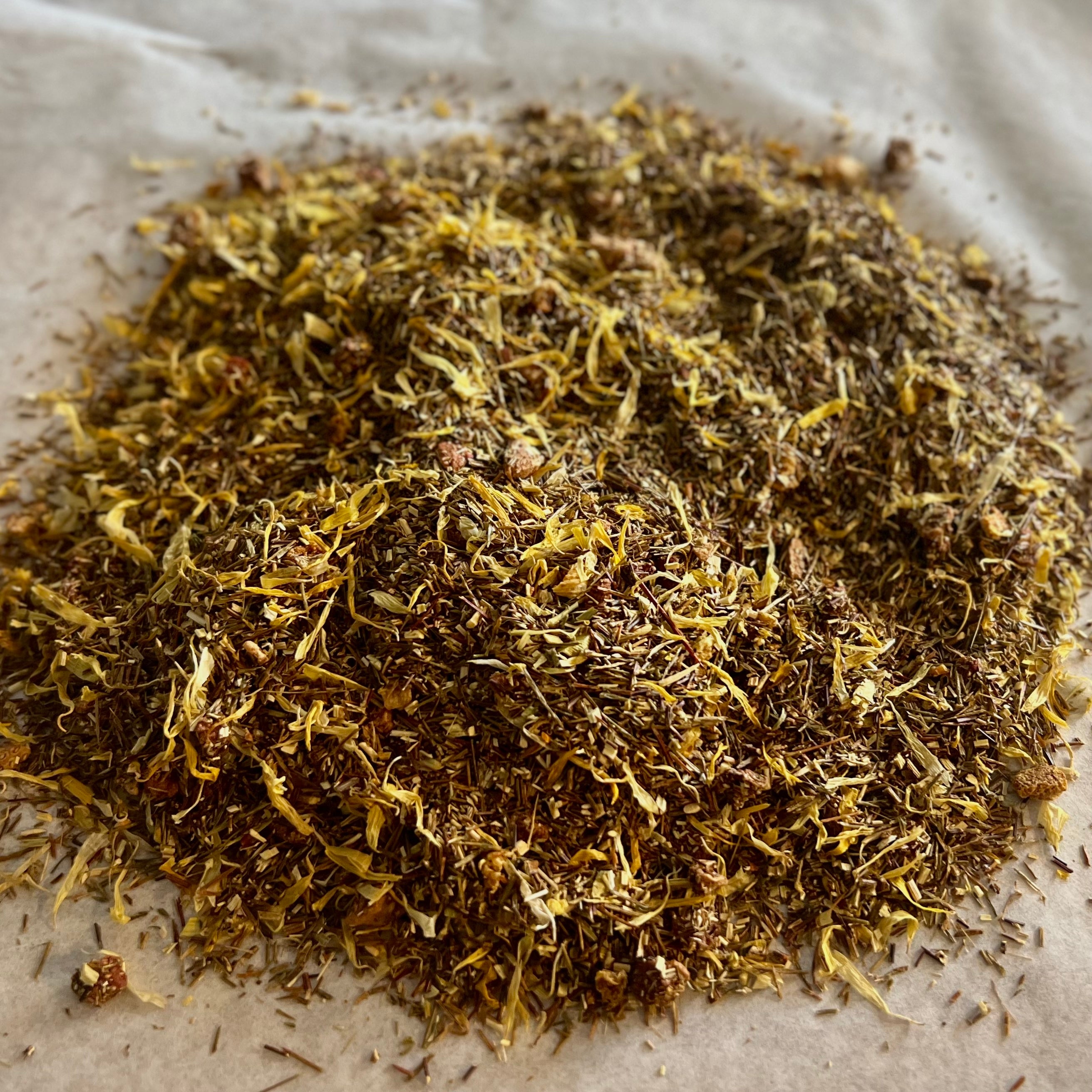 Loose Citrus Peach rooibos tea blend with dried citrus and peach petals on parchment paper background