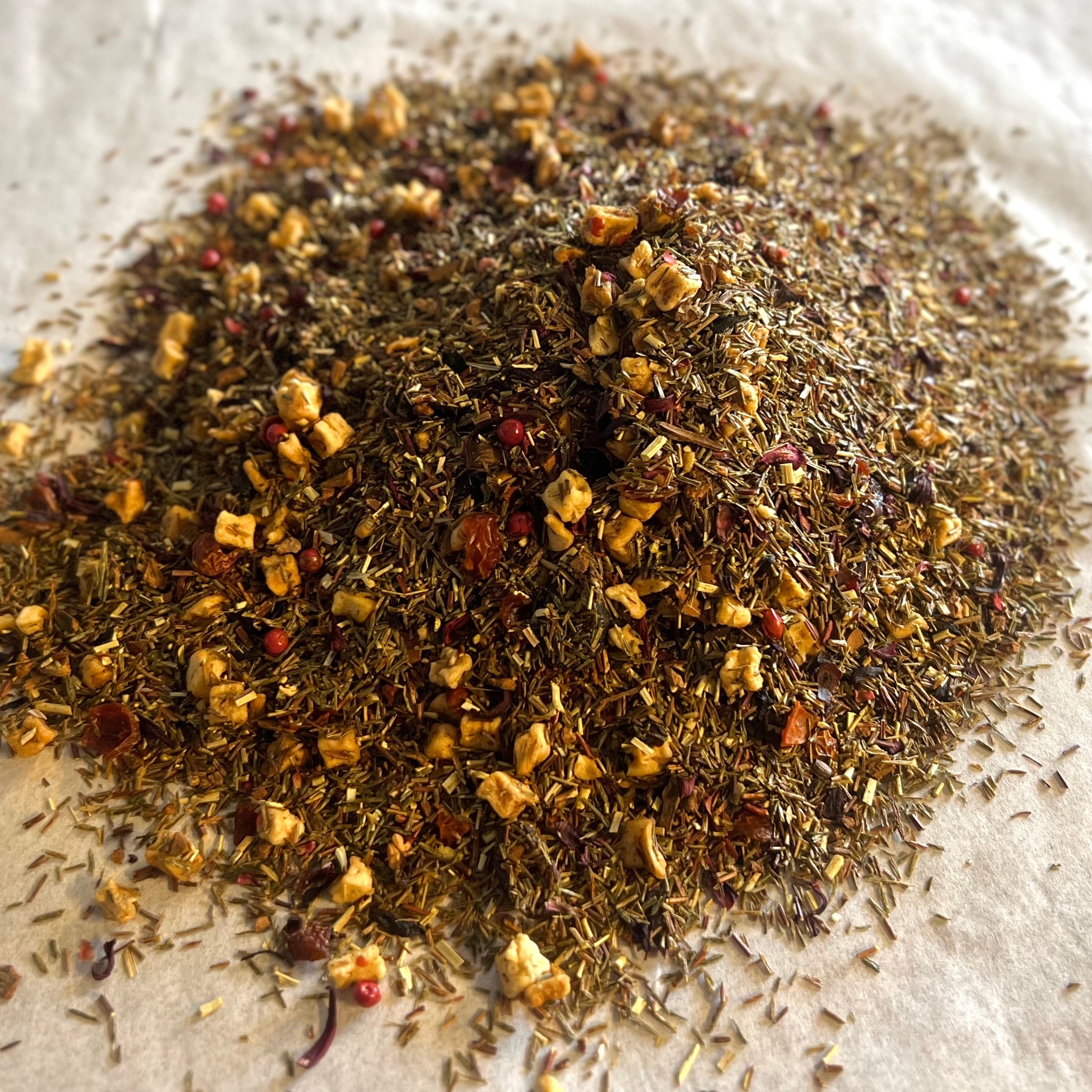 Close-up of loose Cranberry Cloud rooibos tea blend with dried cranberry pieces and cream-flavored green rooibos leaves