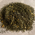 Close-up of loose Echinacea Blend herbal tea with peppermint, echinacea, orange peel, and eucalyptus leaves on a light surface