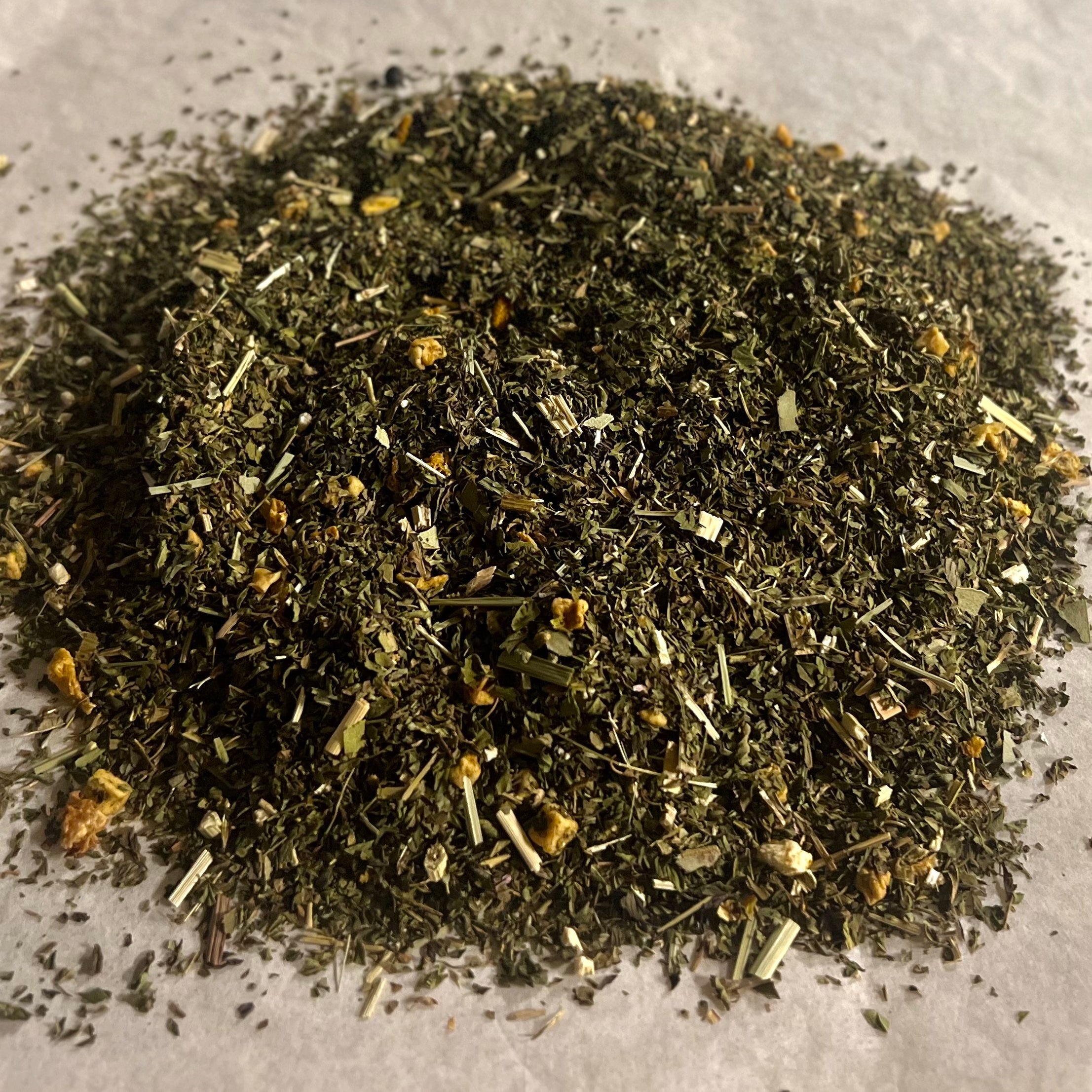 Close-up of loose Echinacea Blend herbal tea with peppermint, echinacea, orange peel, and eucalyptus leaves on a light surface