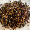 Close-up of loose Heartful Hibiscus tea blend with hibiscus, butterfly pea flowers, and rose hips for a caffeine-free fruit and flower tea.