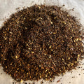 Close-up of caffeine-free Chai No. 82 honeybush tea blend with pumpkin spice and fine loose leaves on a light surface