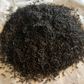 Close-up of loose Irish breakfast black tea leaves showing fine, dark, twisted leaves ready for brewing.