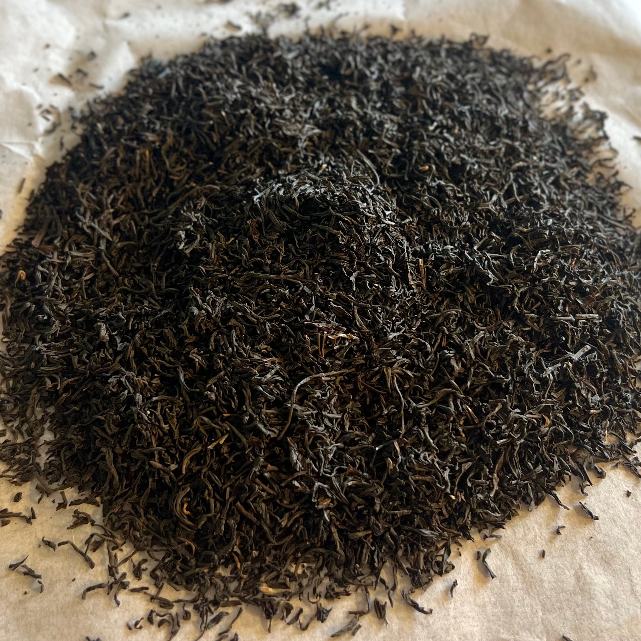 Close-up of loose Irish breakfast black tea leaves showing fine, dark, twisted leaves ready for brewing.