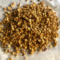 Close-up of dried peach pieces for Just Peachy fruit and flower tea blend on light surface, naturally caffeine-free.