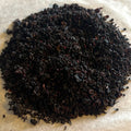 Close-up of Merlot Mornings loose tea blend with dark, finely textured leaves evoking rich berry and wine notes.