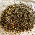 Close-up of loose Montana Dream sleep tea blend with chamomile, lavender, lemon balm, and valerian on parchment paper.