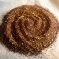Close-up of loose Rooibos chai blend with fine spices and vanilla notes on parchment paper, caffeine-free and aromatic.