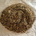 Close-up of Support | Him spiced herbal tea blend with eleuthero, astragalus, and fo-ti on parchment paper.