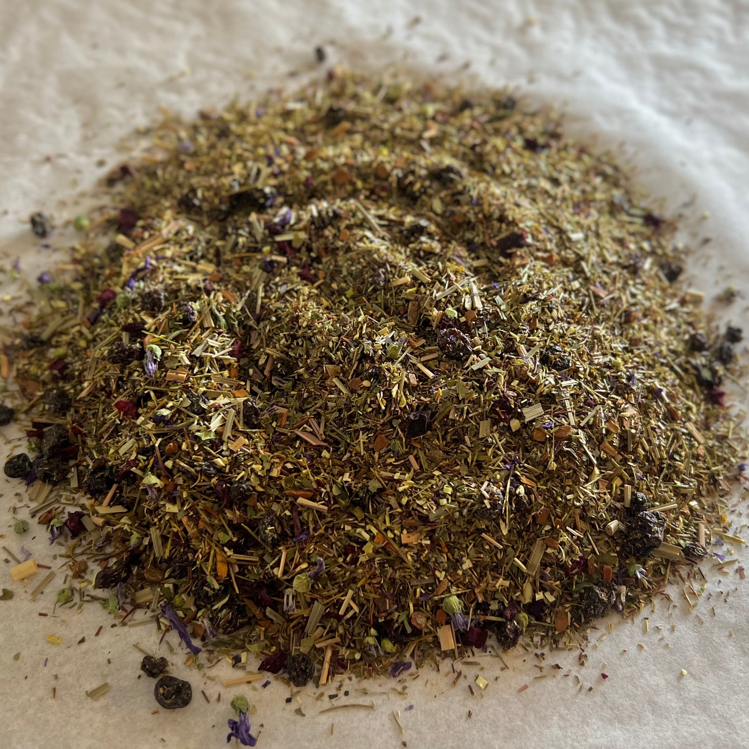 Loose Sweet Blueberry Bake rooibos tea blend with dried blueberry pieces and warm spiced fruit notes on parchment paper