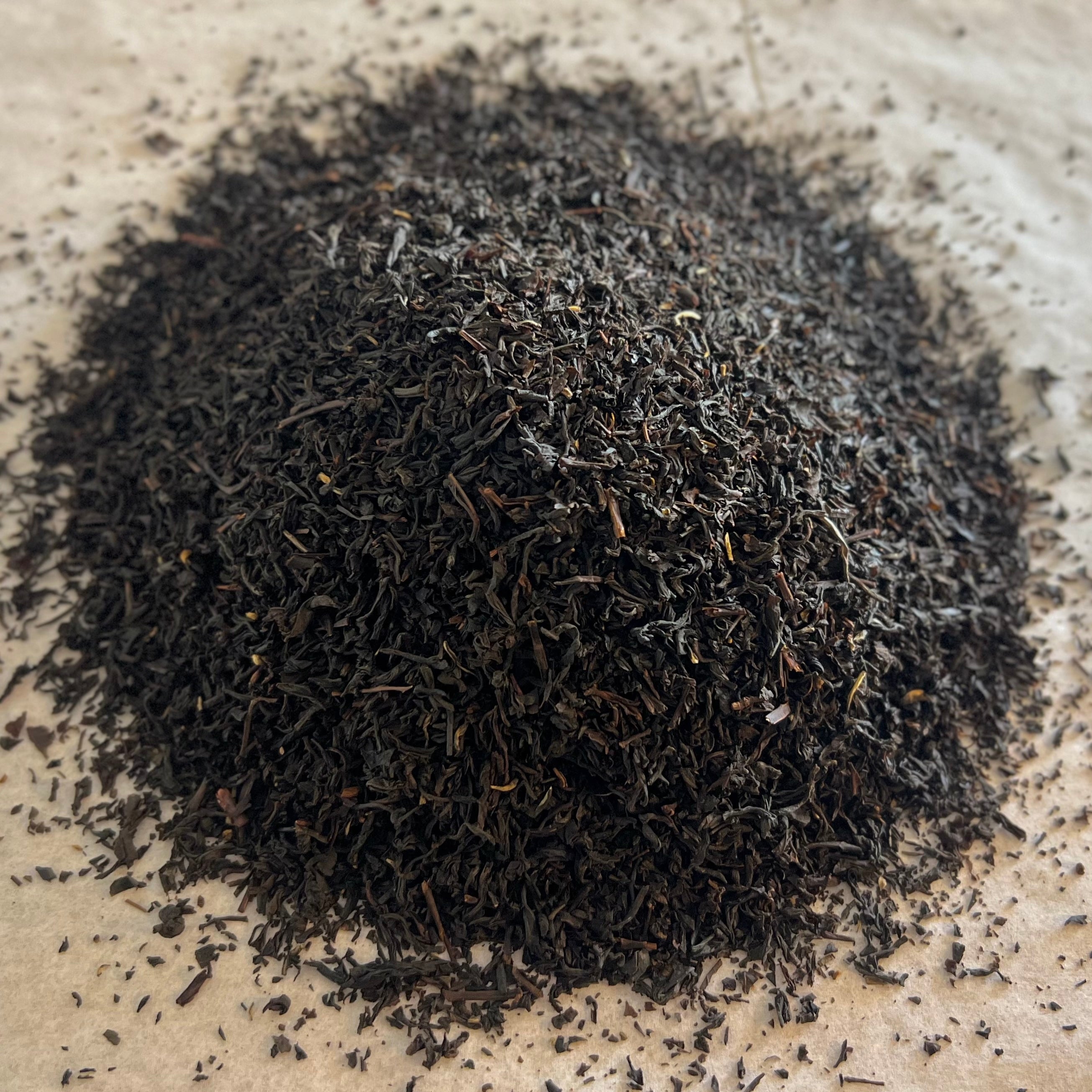 Close-up of loose black tea leaves for The Painted Lady blend with bold dark leaves and hints of citrus notes visible