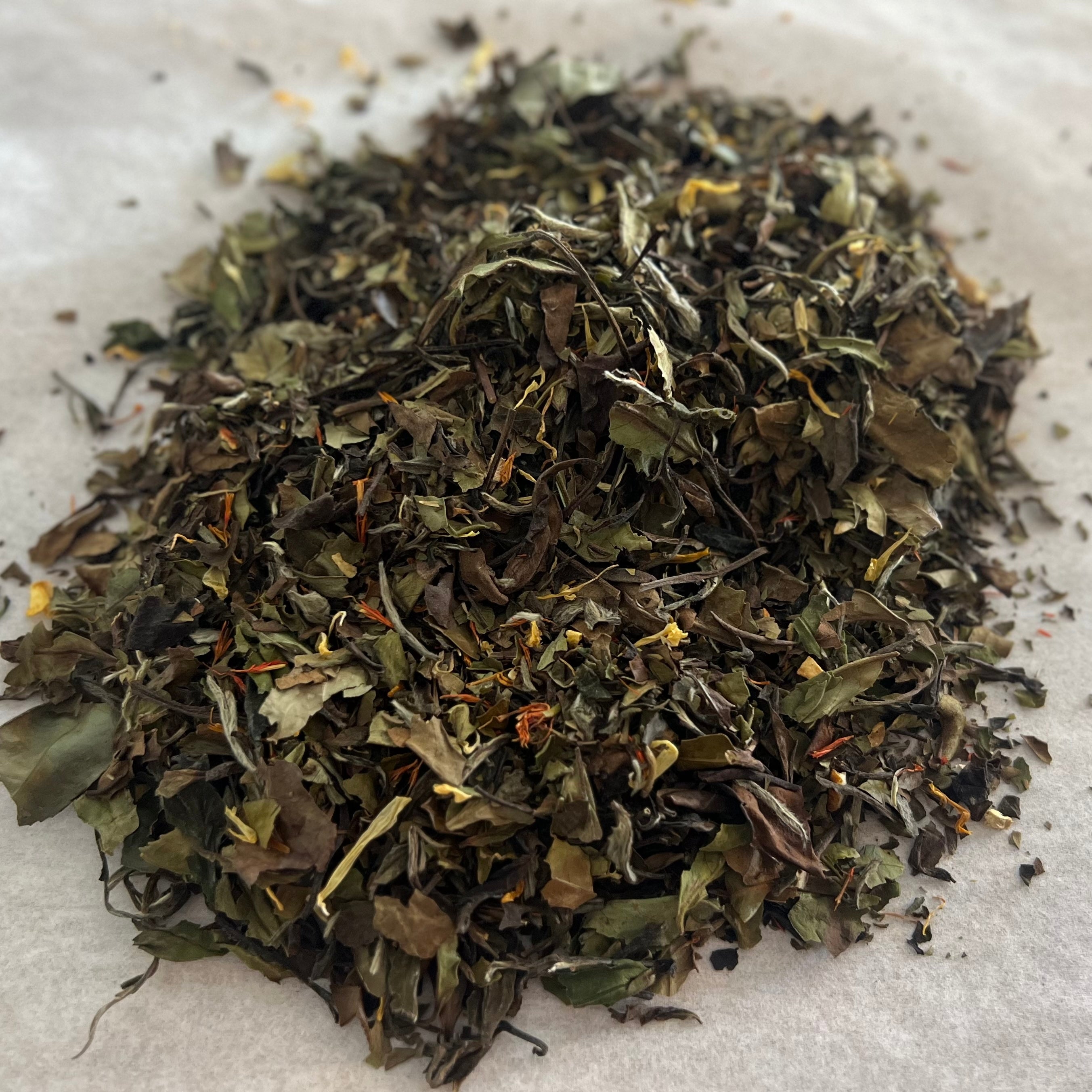 Loose White Peach tea blend with white tea leaves, safflowers, ginger root, calendula, orange peel, and peach pieces
