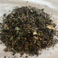 Loose Chinese white tea leaves with peony petals, light and delicate with subtle natural hues on a neutral surface