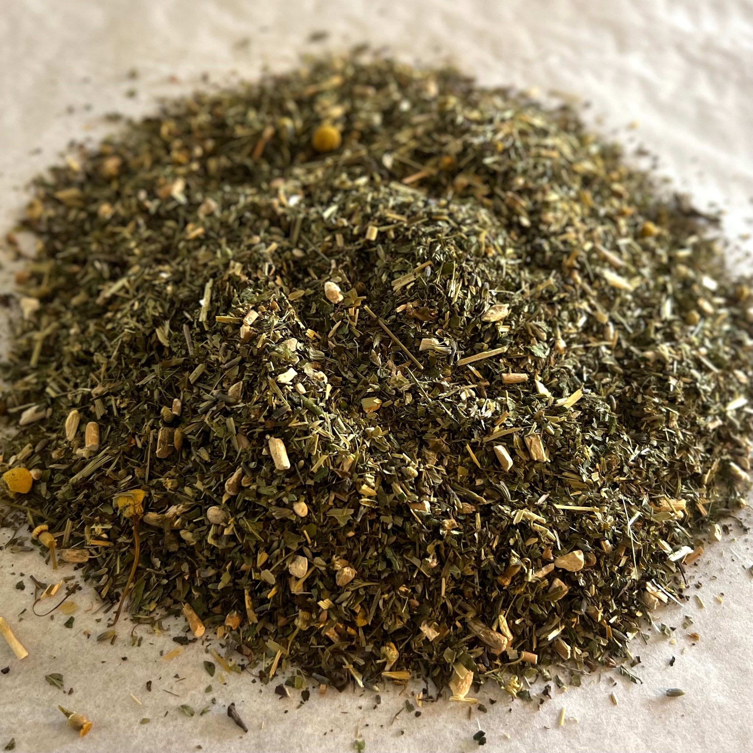 Close-up of Zen herbal tea blend with ashwagandha, chamomile, and passionflower pieces on a light textured surface