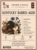 A vintage-style tea label for R&R Rhythms & Rituals, featuring the flavor name Kentucky Barrel-Aged. The cream-colored label includes illustrated tea leaves, flowers, a cinnamon stick, and fruit, with a listed ingredients section and brewing icons at the bottom.