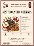 Rhythm & Rituals 'Misty Mountain Mornings' tea collection label, featuring a vintage-style illustration of green tea leaves, cinnamon sticks, apple slices, rose hips, and orange flowers on a cream background with a brown border.