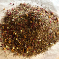 Close-up of loose Raspberry Truffle tea blend with green rooibos, apple pieces, mini white chocolate, and raspberry hints