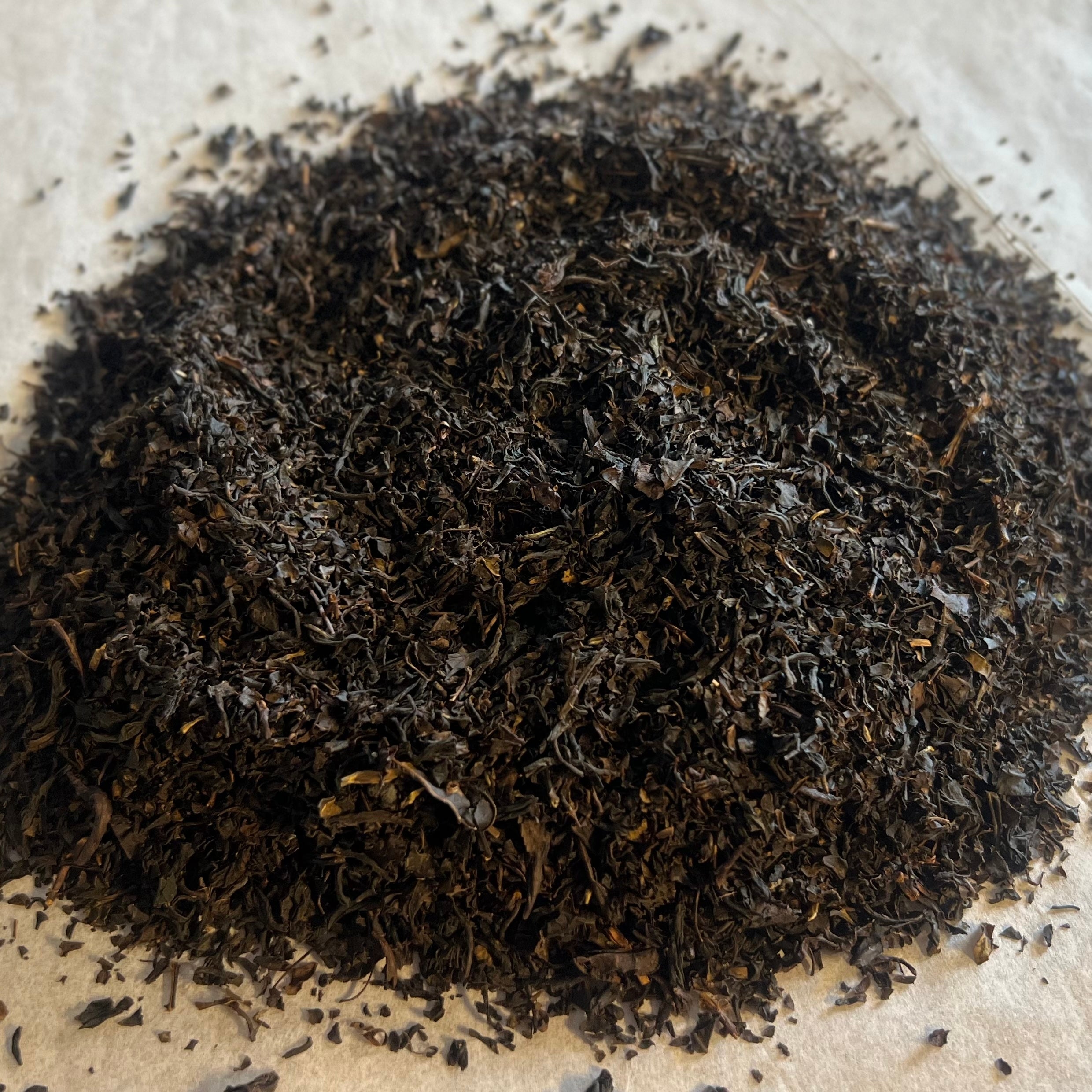 Close-up of loose Russian Caravan black tea leaves, dark and finely textured, ready for brewing a robust cup.