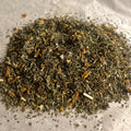 Close-up of Support | Inspiration loose wellness tea blend with mixed dried herbs and citrus peel on parchment paper