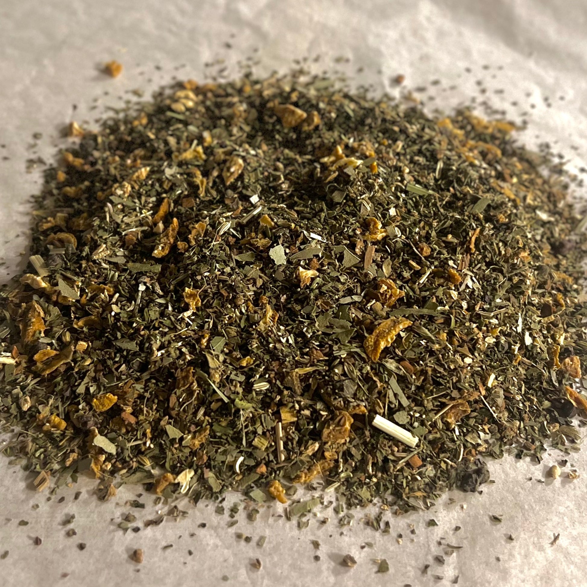 Close-up of Support | Inspiration loose wellness tea blend with mixed dried herbs and citrus peel on parchment paper