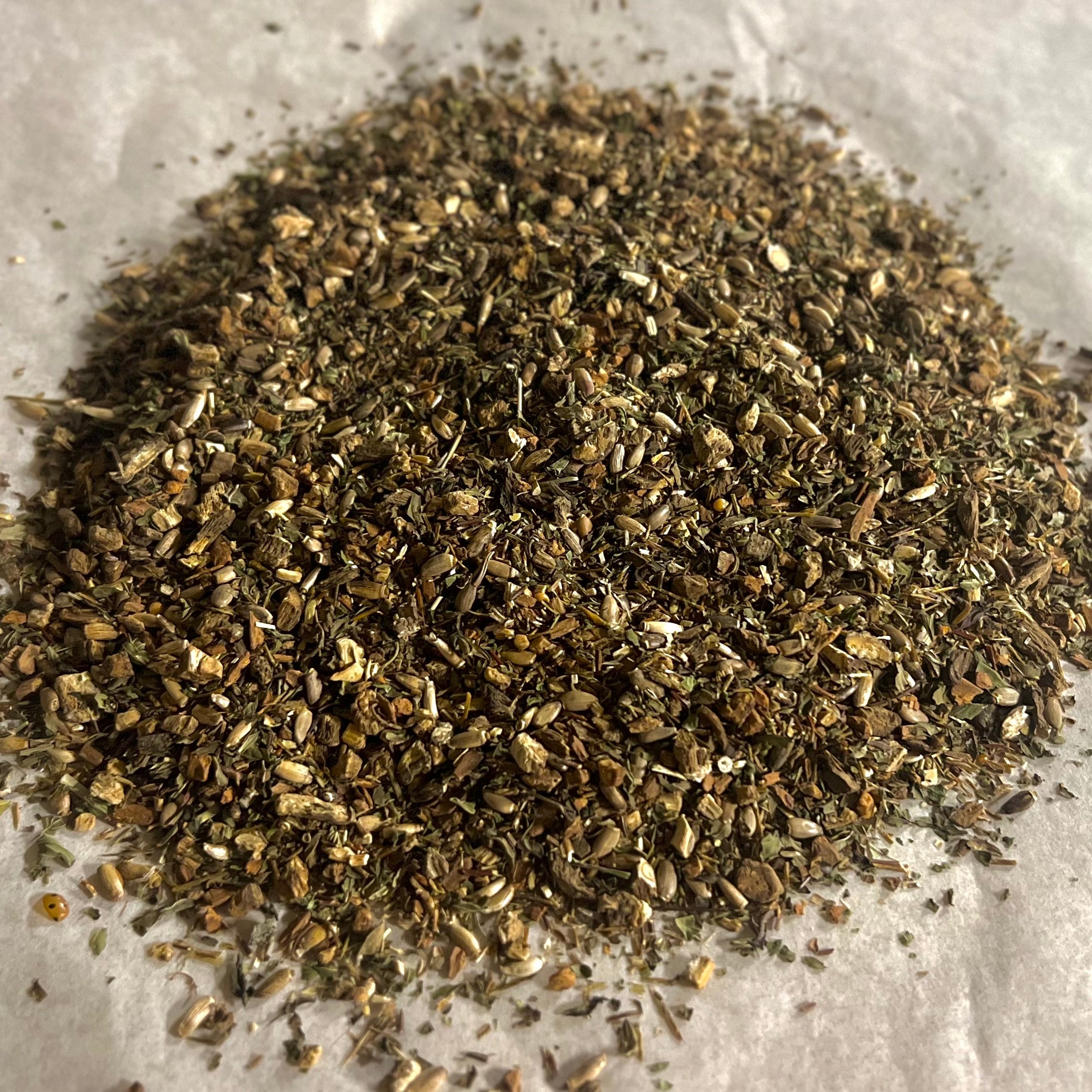 Close-up of Support | Liver loose tea blend with burdock, milk thistle, and green rooibos on a light background