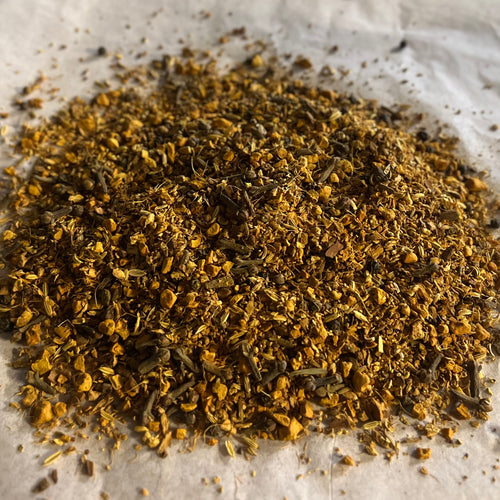 Close-up of Chai No. 57 loose blend with turmeric, spices, and herbs, naturally caffeine-free, on parchment paper.