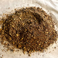 Close-up of Oh My! All the Chai Sampler showing finely ground, rich brown chai spices and tea blend on parchment paper.