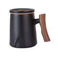 Matte black porcelain tea mug with wooden handle and lid, featuring subtle textured mountain design, 12 fl. oz. capacity.