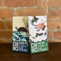 Two bars of dark chocolate with traditional herbs, one with turtle art and the other with dragon illustration on packaging