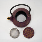 Top view of purple honeycomb textured cast iron teapot with lid and metal strainer on white background