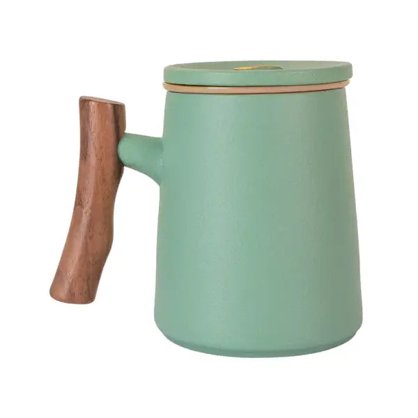 Matte green porcelain mug with wooden handle, fitted lid, and removable infuser for loose leaf tea brewing.