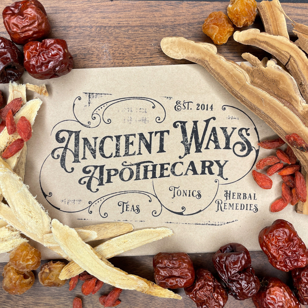 Dried traditional herbs including Huang Qi, Bai Zhu, Goji berries, and reishi mushrooms around an Ancient Ways Apothecary card on wood
