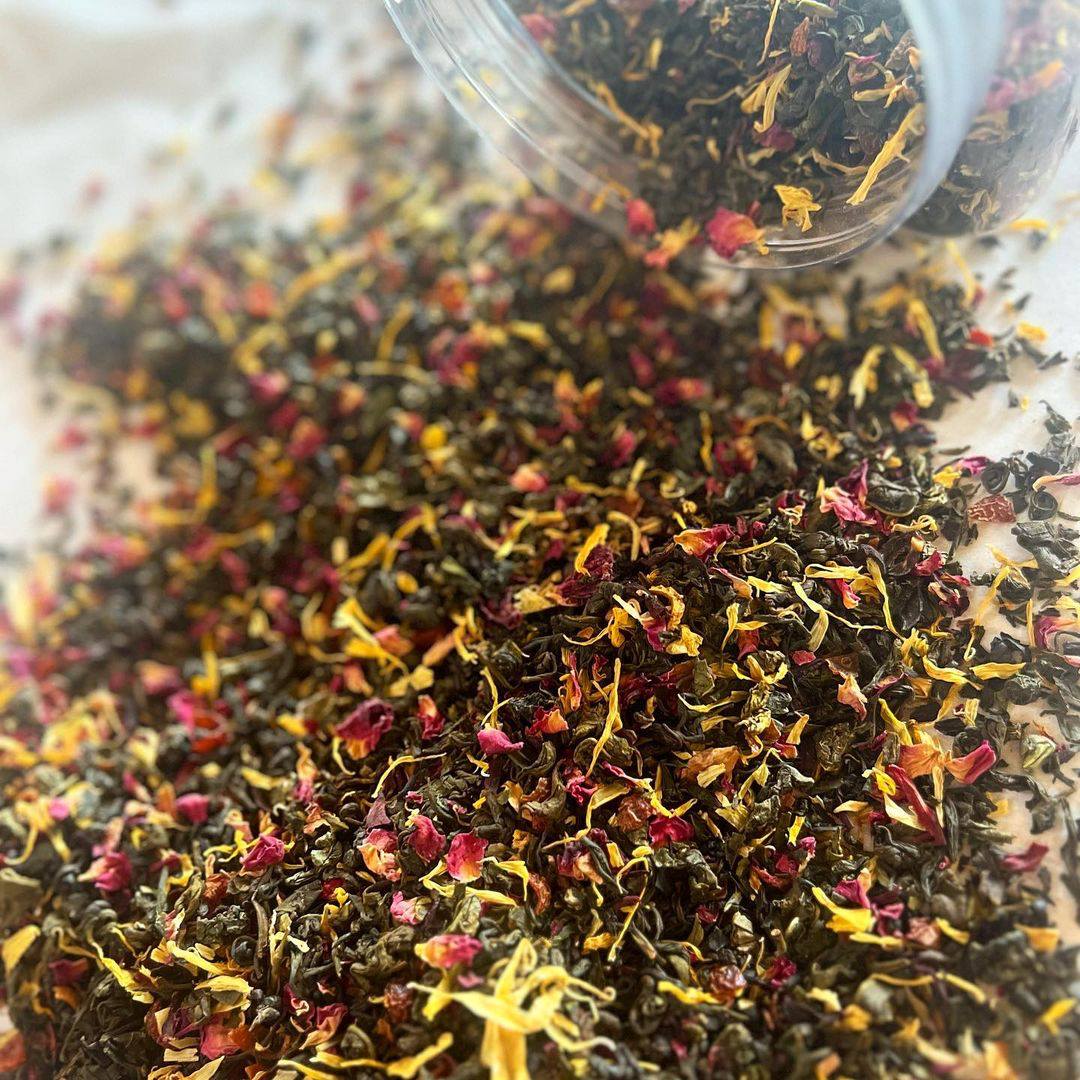 Close-up of Rocky Mountain Rosé loose tea blend with green and oolong leaves, hibiscus, rosehip, and colorful flower petals.